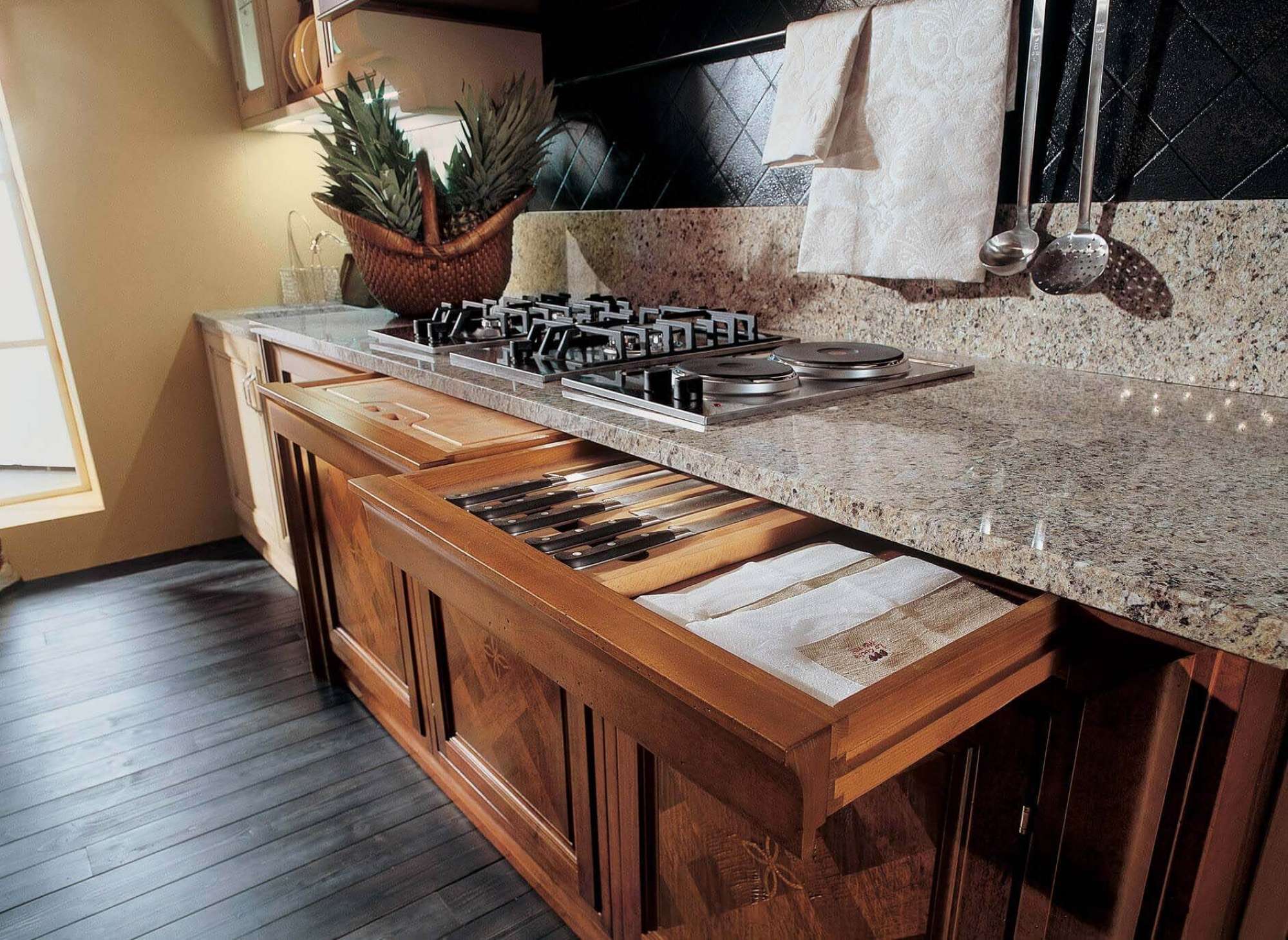 Cucina su misura di lusso in legno massiccio di noce, dettaglio cassetto posate e zona cottura, design Martini Verona