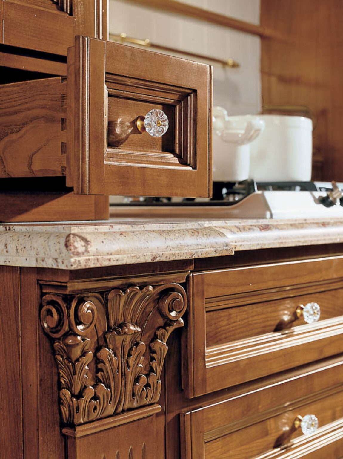 Cucina su misura in legno massiccio di noce con decori intagliati a mano, dettaglio cassetti, design Martini Verona