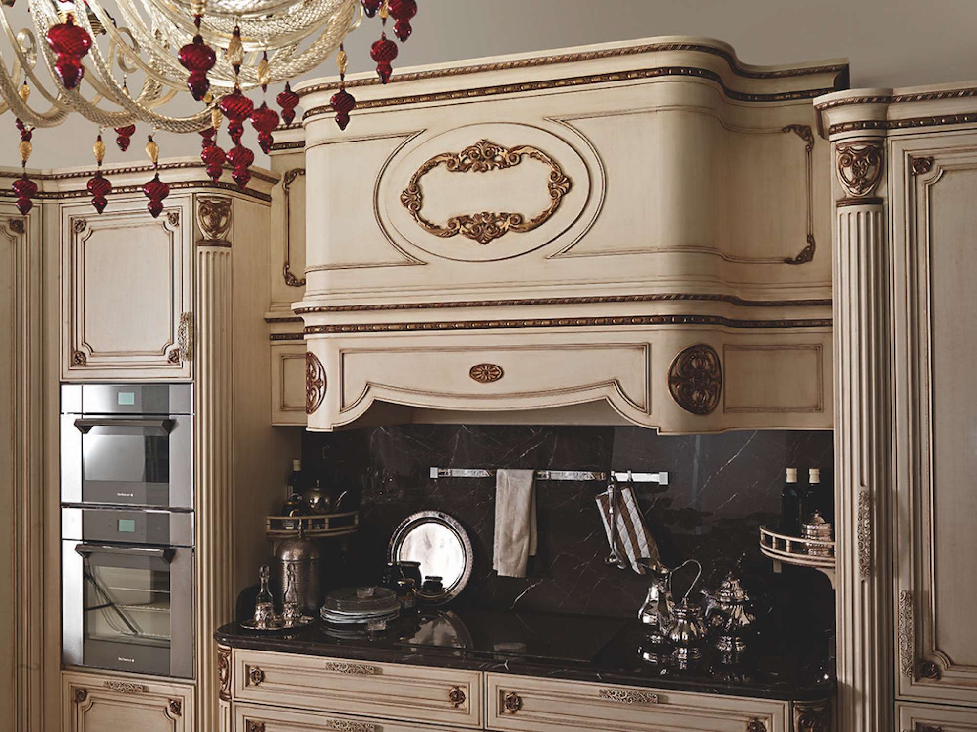 Cucina su misura di lusso laccata vaniglia vintage con decori in foglia oro, dettaglio zona cottura e cappa, design Martini Verona