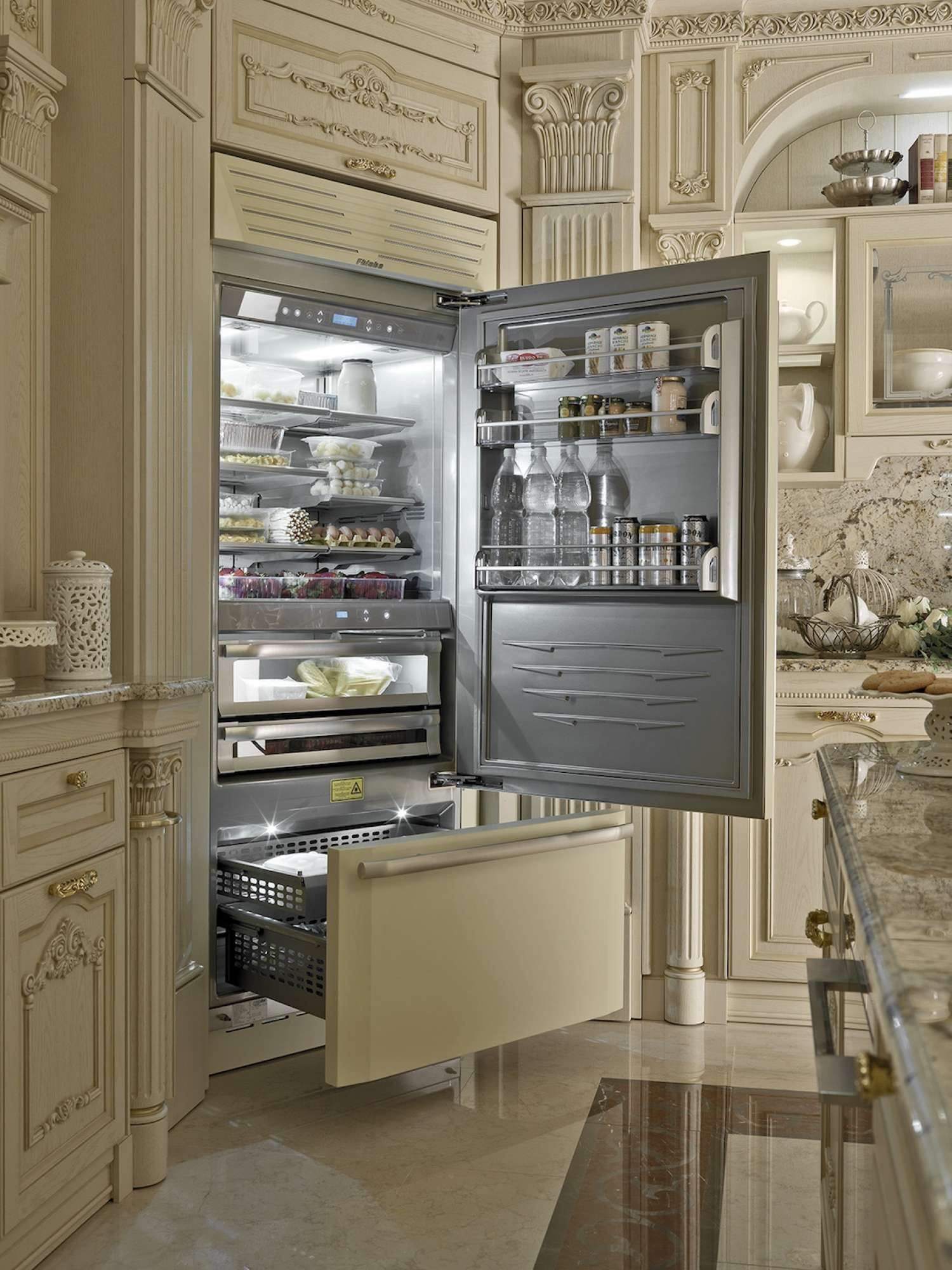 Cucina di lusso su misura in rovere con intagli e finiture dorate, dettaglio frigo incassato, design Martini Verona