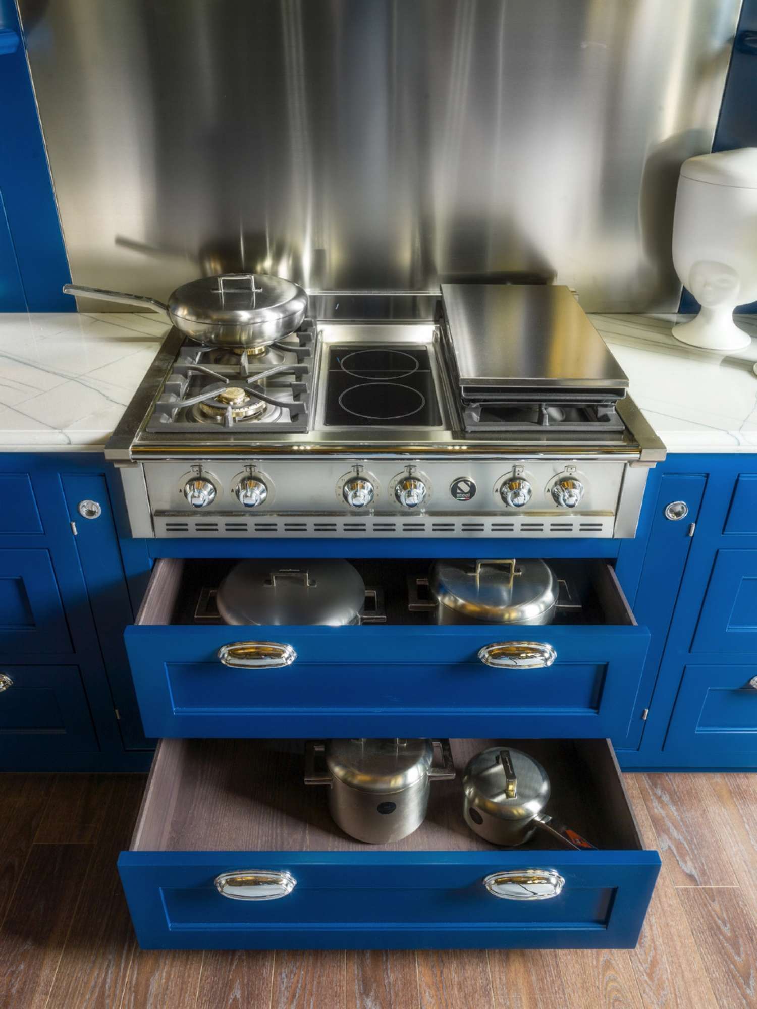 Cucina su misura stile shaker in legno massiccio e laccatura blu e bianca, dettaglio piano cottura e cassetti, design Martini Verona