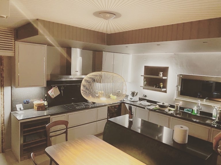 Cucina su misura a Sona, Verona, con isola operativa, cappa integrata e illuminazione sospesa di design, progetto contemporaneo realizzato da Martini Verona