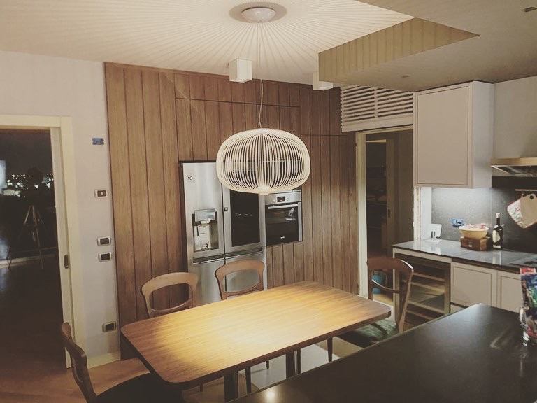 Cucina su misura a Sona, Verona, con boiserie in legno, tavolo integrato ed elettrodomestici a colonna, realizzata da Martini Verona