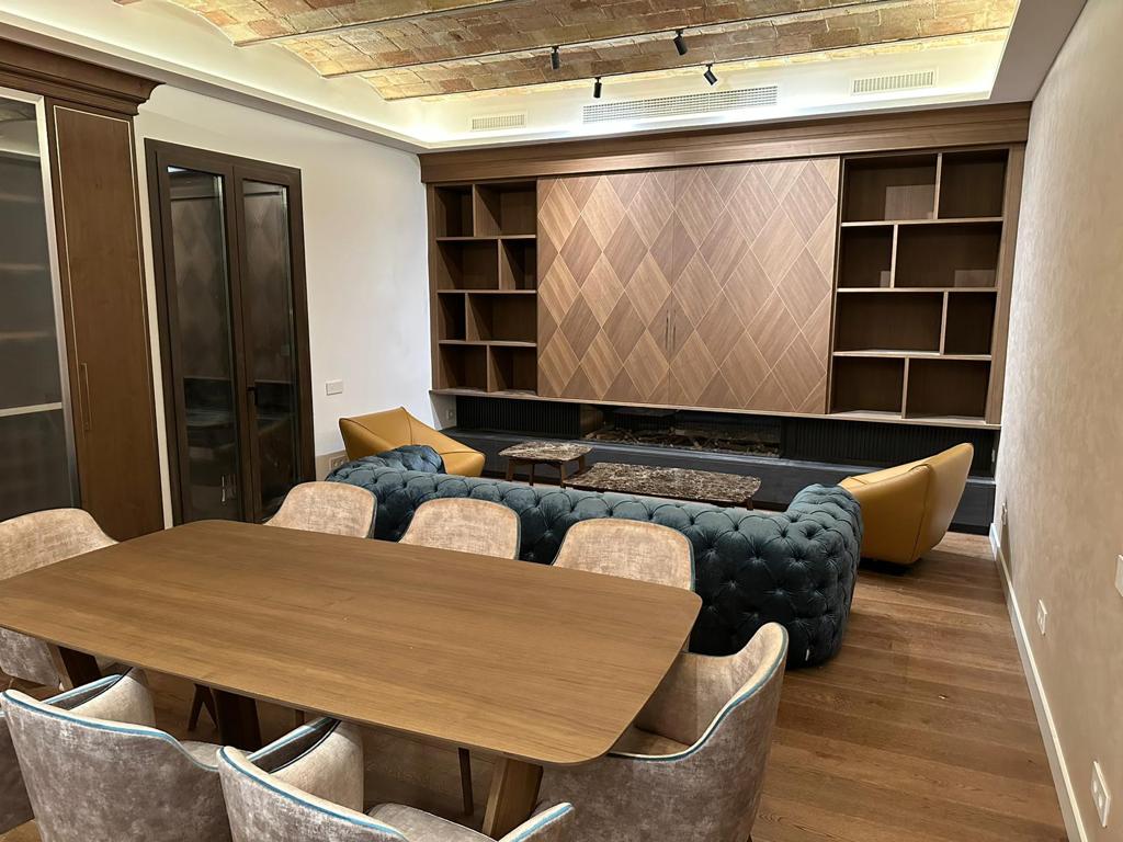 Arredo living su misura con boiserie e libreria in legno a Barcellona realizzato da Martini Verona