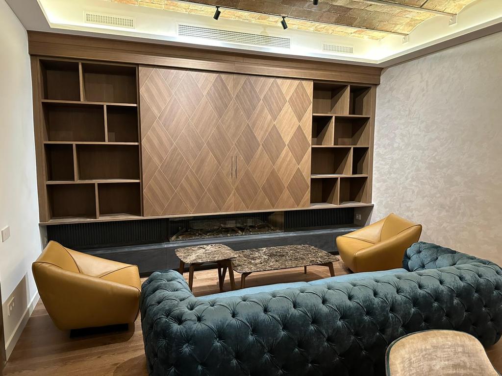 Arredo living su misura con boiserie e libreria in legno a Barcellona realizzato da Martini Verona