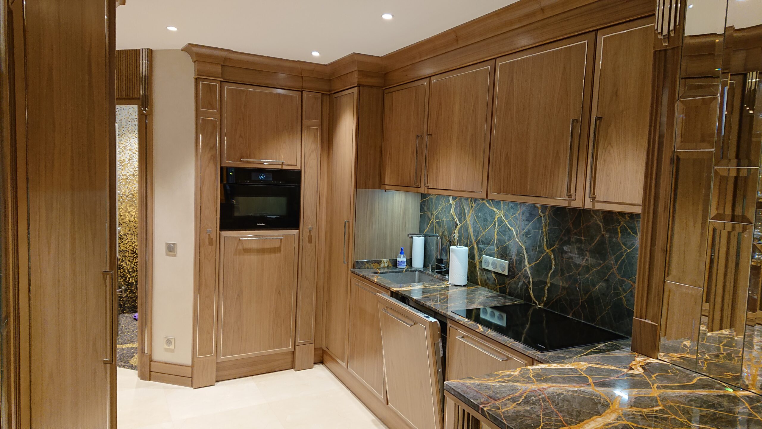 Cucina su misura in legno realizzata da Martini Verona a Cannes con piano e alzata in pietra naturale