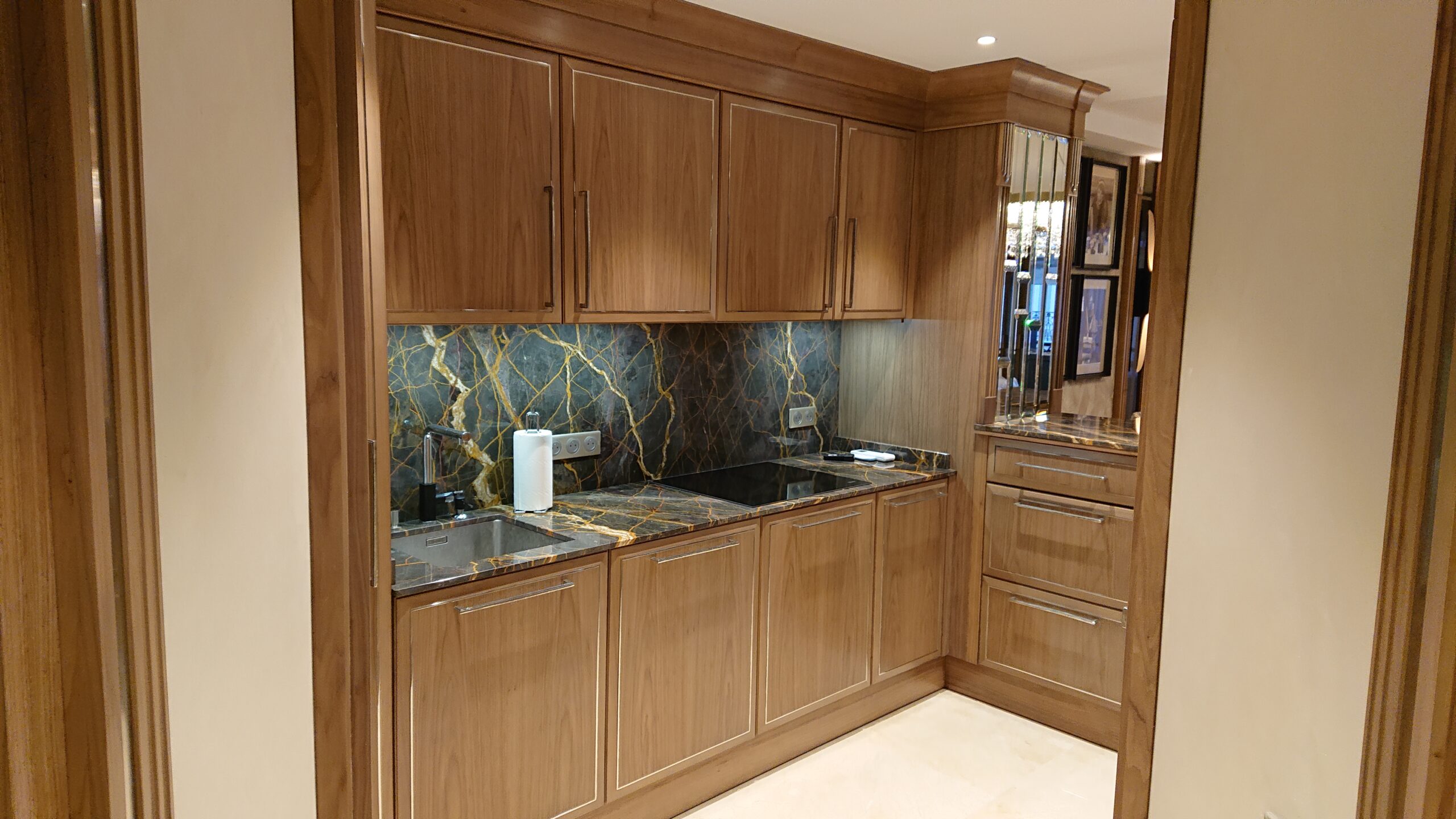 Cucina su misura in legno realizzata da Martini Verona a Cannes con piano e alzata in pietra naturale