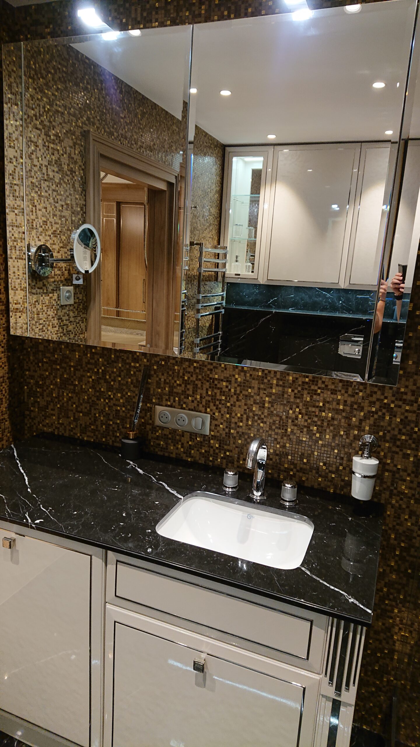 Bagno su misura a Cannes con mobile lavabo personalizzato, piano in marmo nero e rivestimento a mosaico dorato, progetto Martini Verona