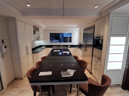 Cucina su misura a Barcellona con isola centrale e piano in pietra nera, realizzata da Martini Verona