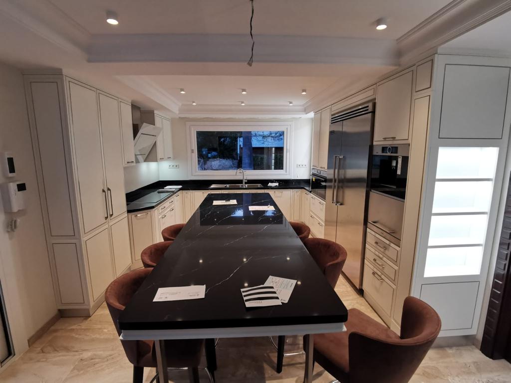 Cucina su misura a Barcellona con isola centrale e piano in pietra nera, realizzata da Martini Verona