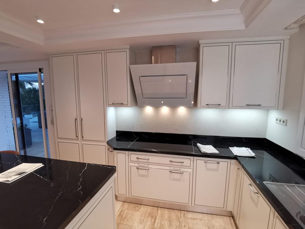 Cucina su misura a Barcellona con composizione angolare e piano in pietra nera, realizzata da Martini Verona