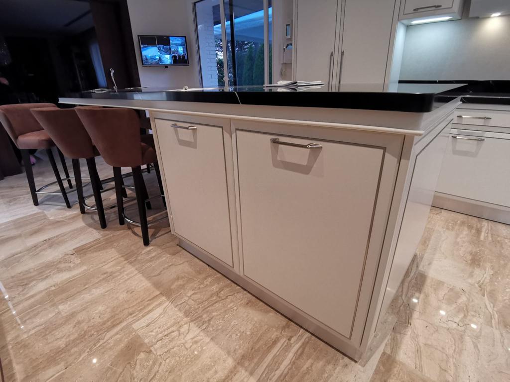 Cucina su misura a Barcellona con isola centrale e piano in pietra nera, realizzata da Martini Verona