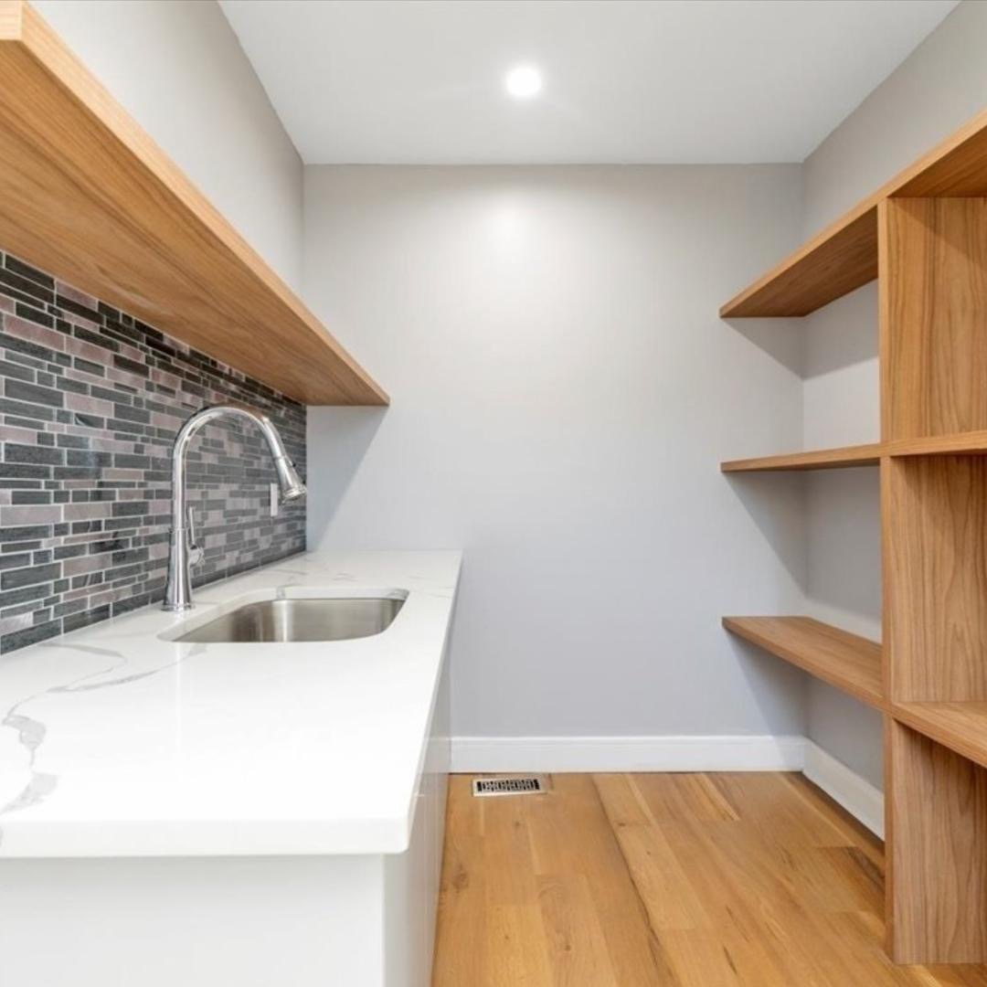 Zona dispensa su misura a New York con mensole in legno e piano integrato, realizzata da Martini Verona