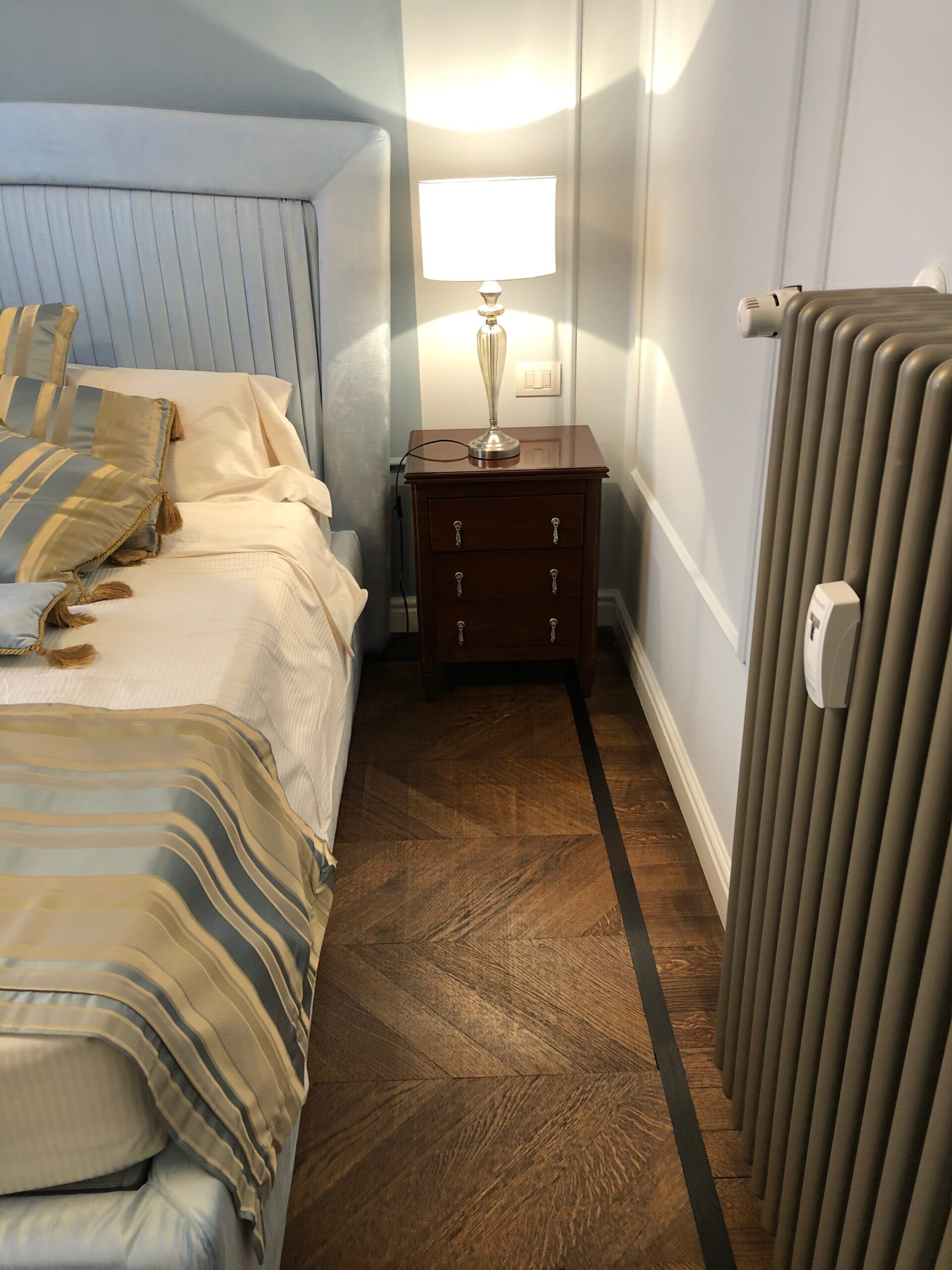 Dettaglio camera da letto su misura con comodino e testiera imbottita realizzato da Martini Verona a Milano