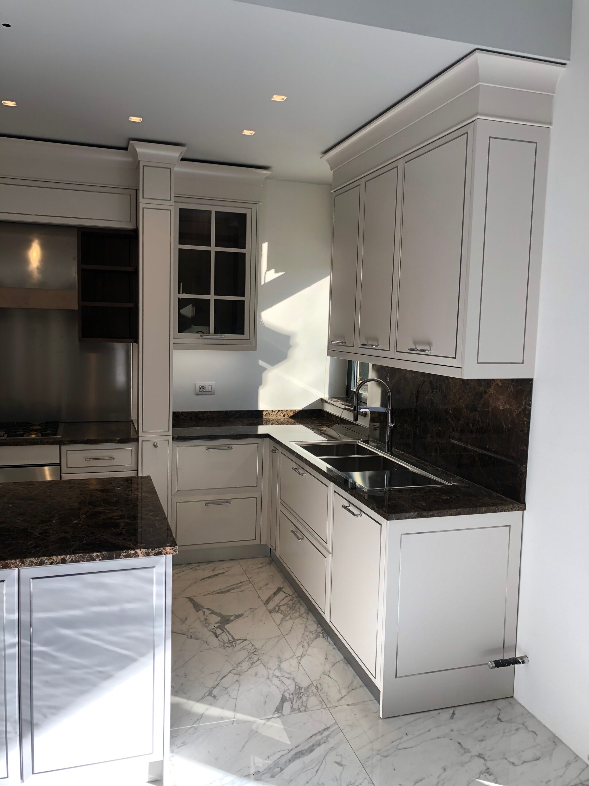 Dettaglio della cucina classica su misura a Piacenza con zona lavello, pensili su misura e piano in marmo, realizzata da Martini Verona