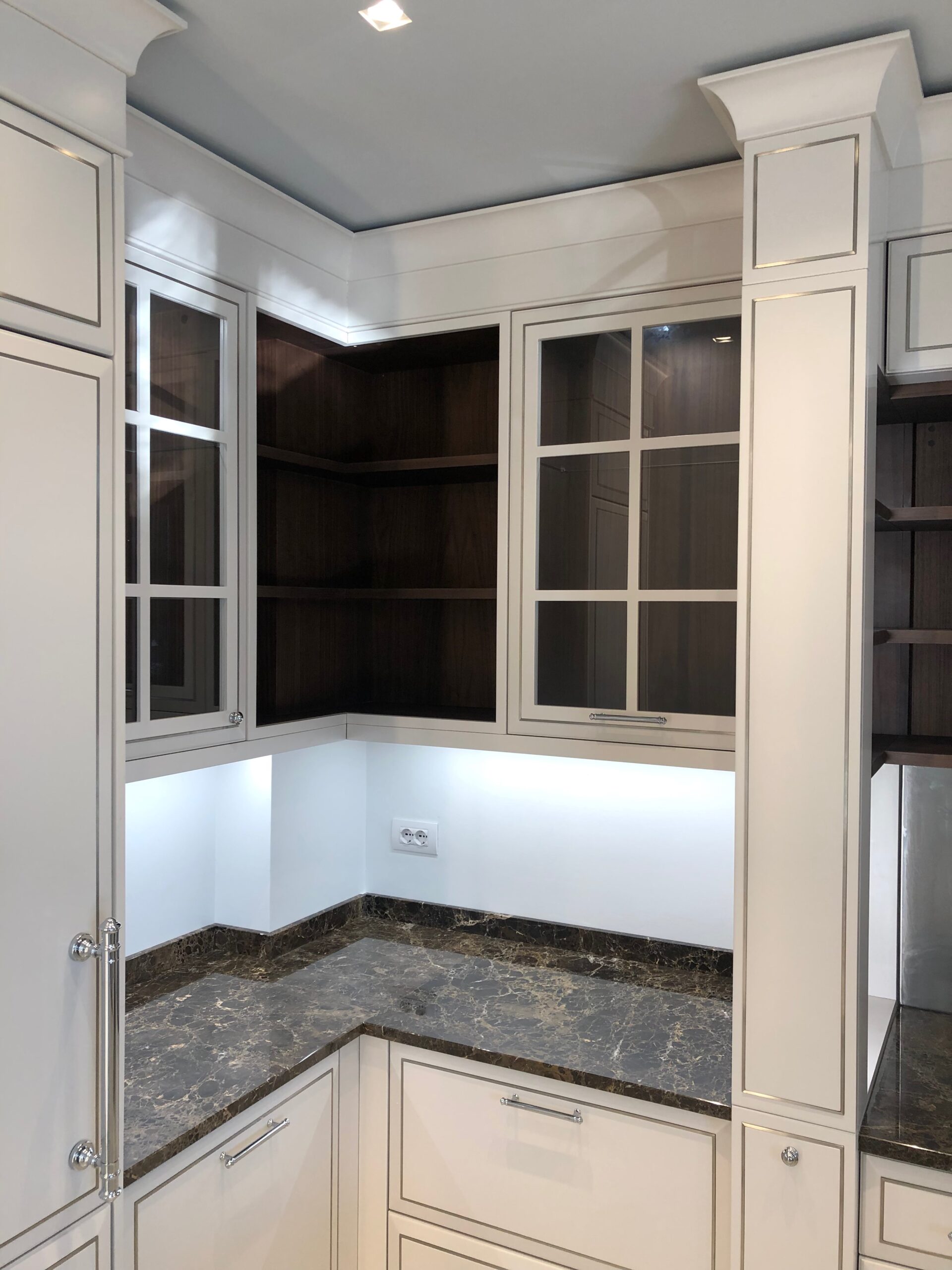 Cucina su misura a Piacenza con angolo attrezzato, pensili vetrati e piano in marmo, progetto classico realizzato da Martini Verona