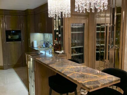 Arredamento su misura a Cannes con isola bar in marmo e pensili specchiati, progetto Martini Verona