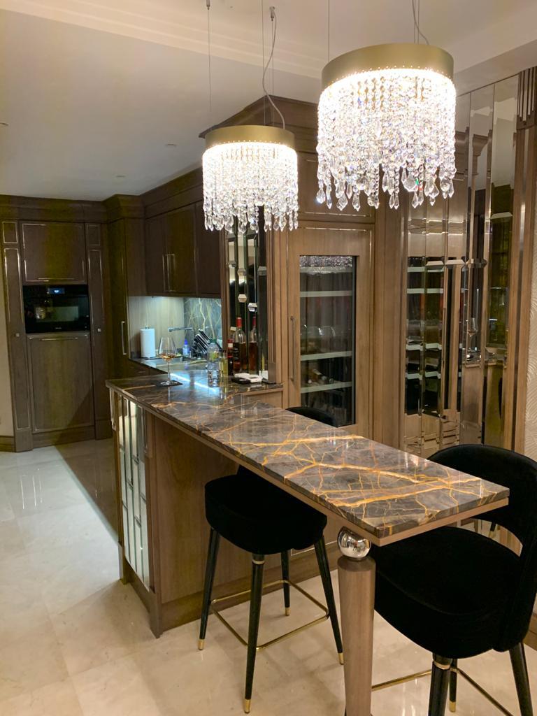 Arredamento su misura a Cannes con isola bar in marmo e pensili specchiati, progetto Martini Verona