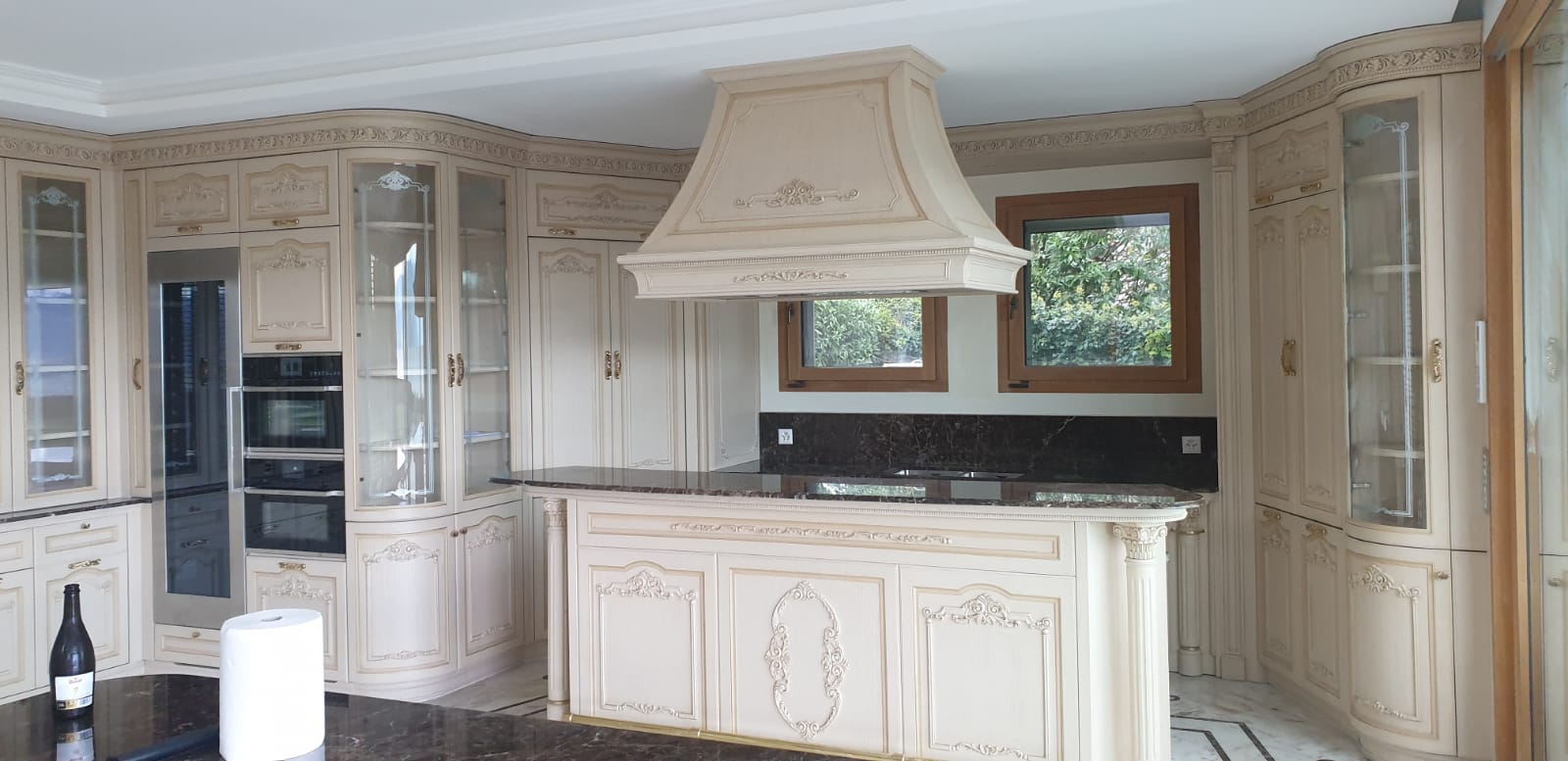 Cucina su misura classica con isola centrale e cappa decorata realizzata da Martini Verona a Losanna, Svizzera