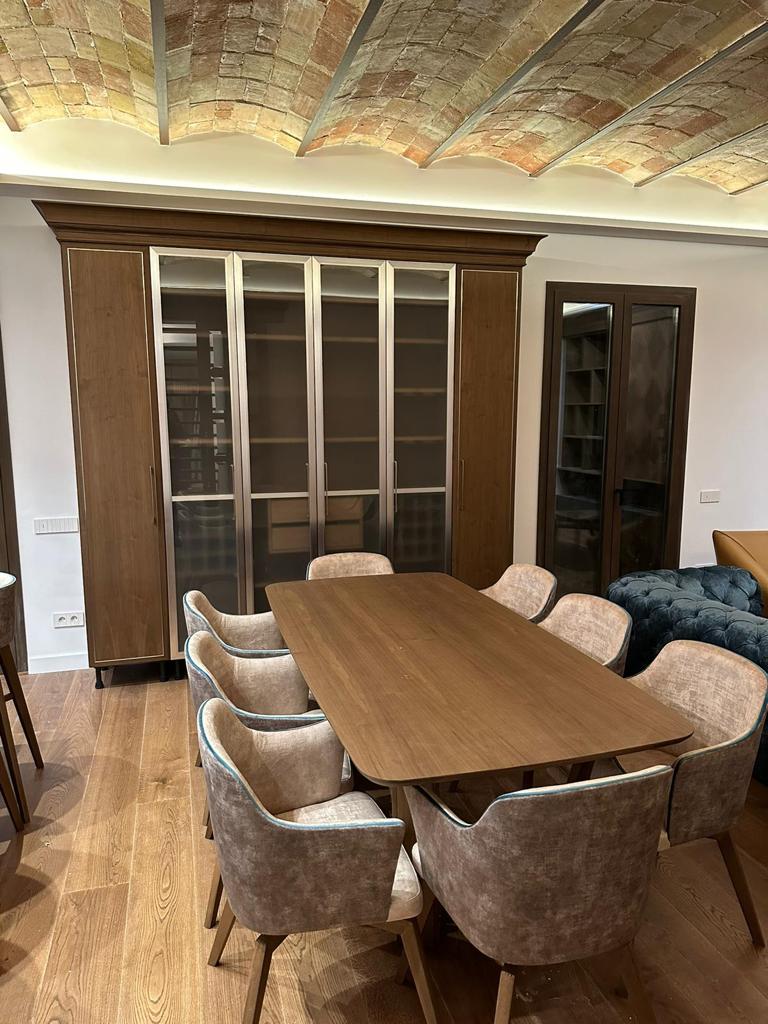 Cucina su misura a Barcellona con boiserie in legno e area living coordinata realizzata da Martini Verona