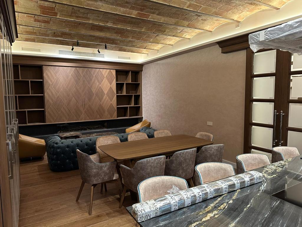 Cucina e arredamento su misura a Barcellona con tavolo da pranzo, boiserie in legno e soffitto a volta in mattoni